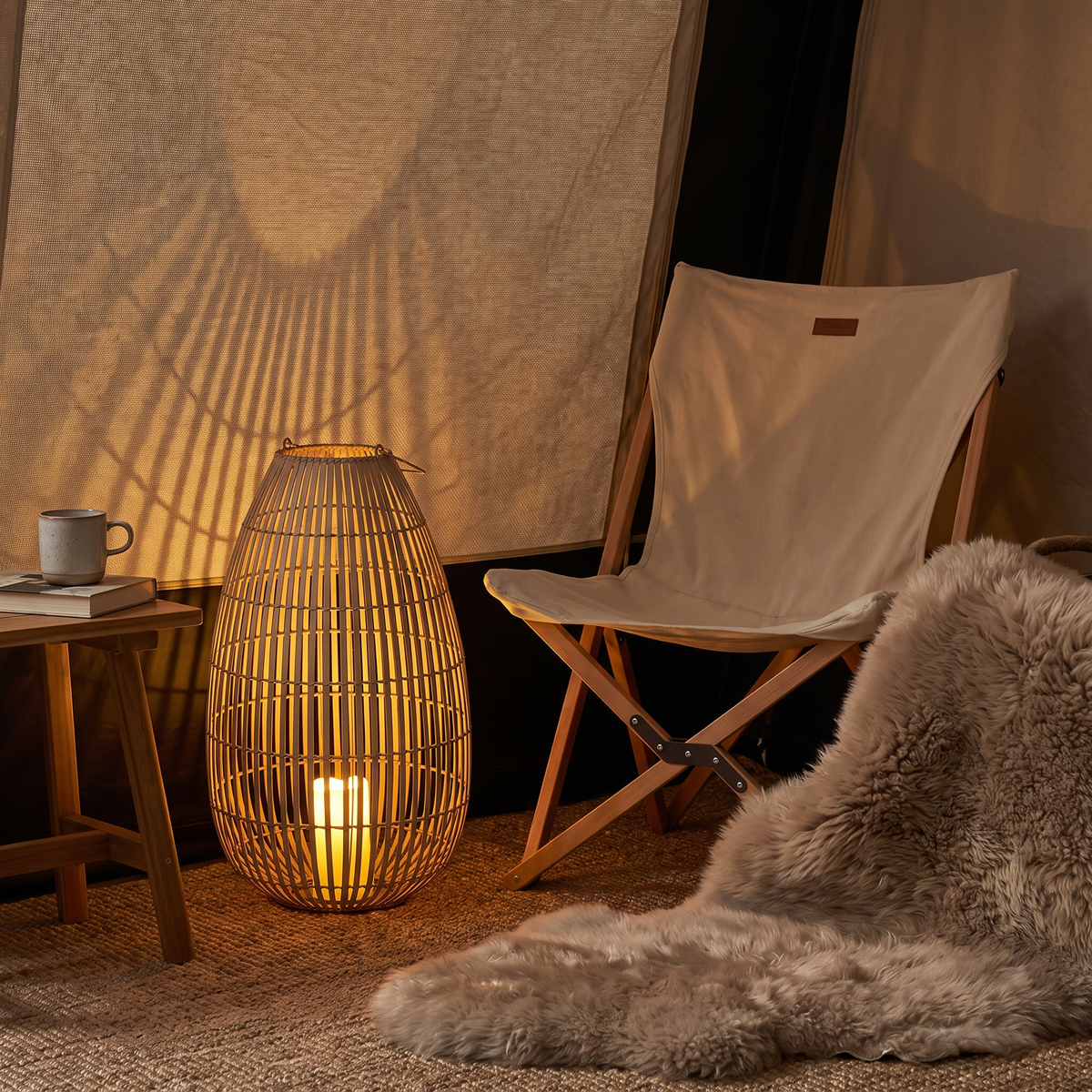 LED-Windlicht Tuva neben Campingstuhl im Vorzelt – zeigt die Höhe von 60 cm